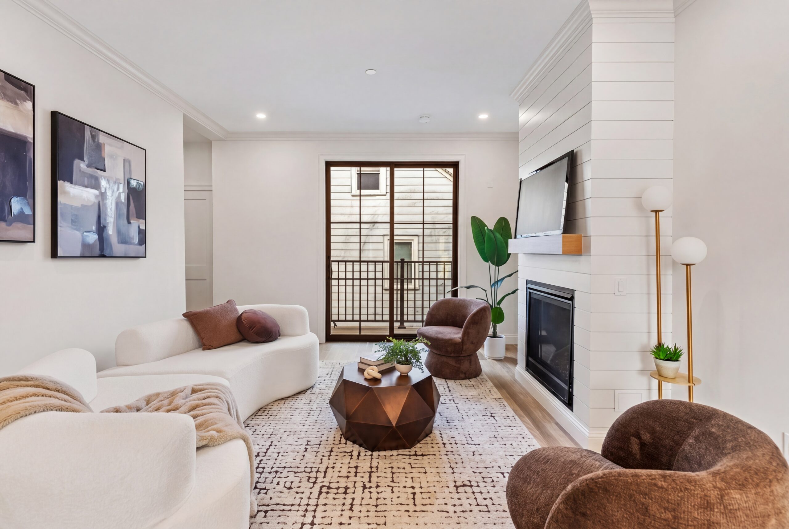 Contemporary living room in Boston multifamily residence featuring modern fireplace, shiplap accent wall, and private balcony access<br />
