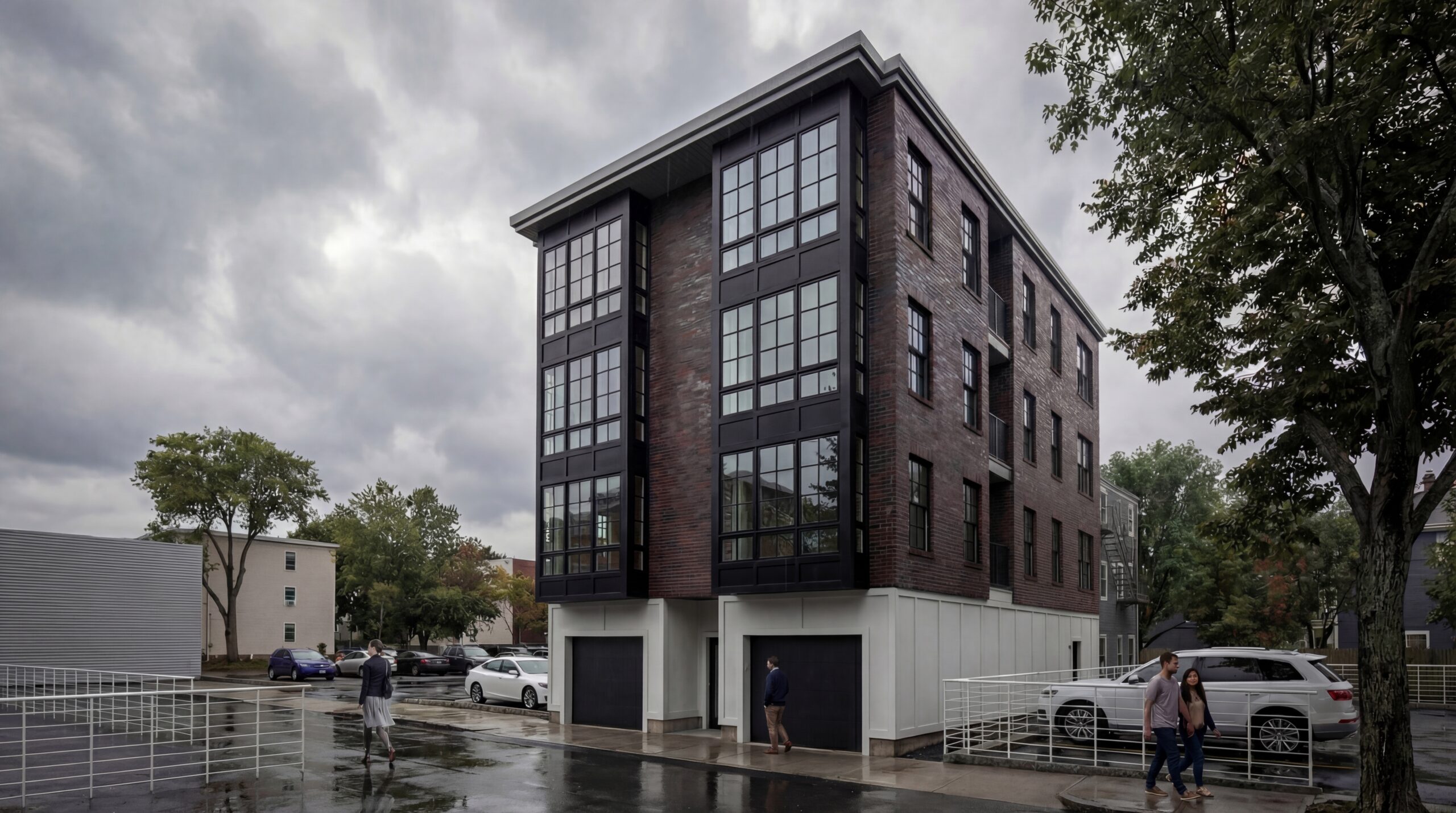 Athens Street Exterior Contemporary multifamily residential building featuring a dark brick façade, expansive black-framed window walls, and modern urban detailing within a dense neighborhood streetscape. The four-story development combines clean contemporary forms with warm masonry materials, integrated garage access, and large vertical glazing elements that create a bold architectural presence against the surrounding residential context.