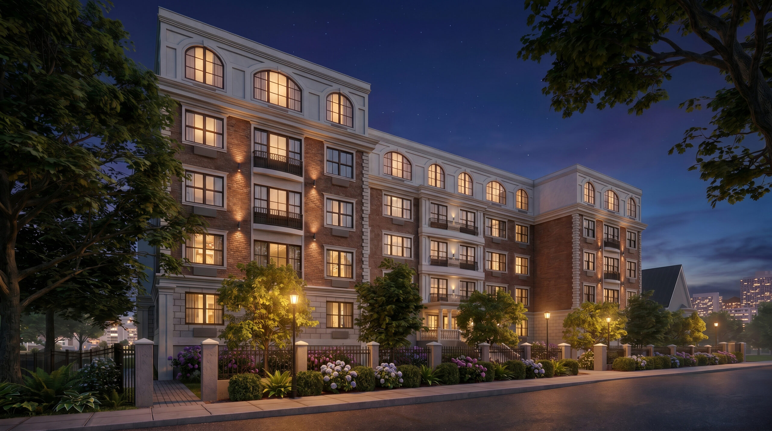 **Luxury multifamily residential building at dusk featuring brick and limestone architecture, illuminated arched windows, landscaped streetscape, balconies, and upscale apartment residences in a walkable urban neighborhood.<br />
